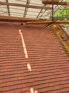 vue d'une partie du toit déjà recouvert de tuiles plates